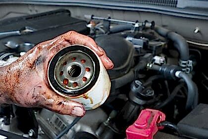 Auto mechanic holding oil filter